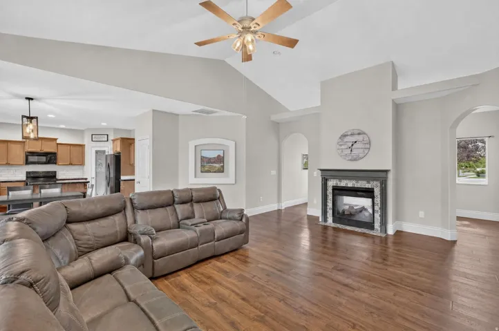 Vaulted ceilings, wood-finish flooring, and a fireplace with a decorative tile surround