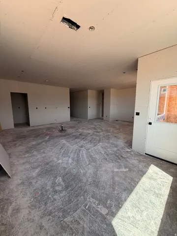 Unfinished interior walls, exposed ceiling framing, and concrete flooring