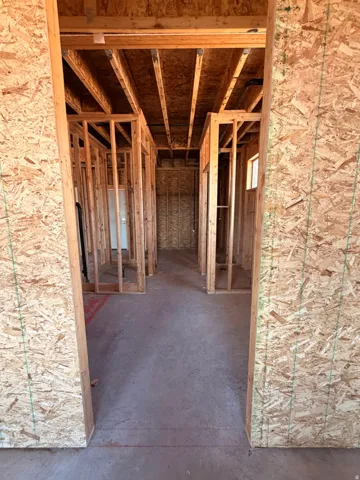 Unfinished interior framing with exposed ceiling joists and subflooring