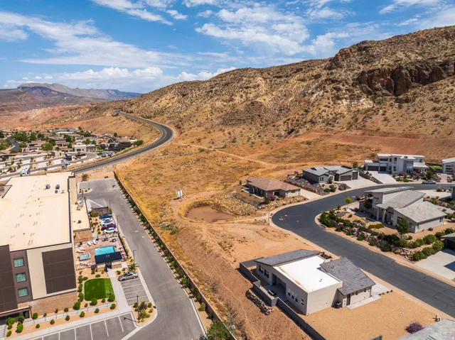 Modern residential structures on sloped terrain, featuring paved roads and landscaping
