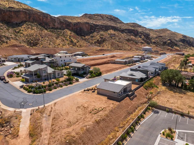 Modern residential neighborhood featuring diverse architectural styles, paved streets, and a mountainous backdrop