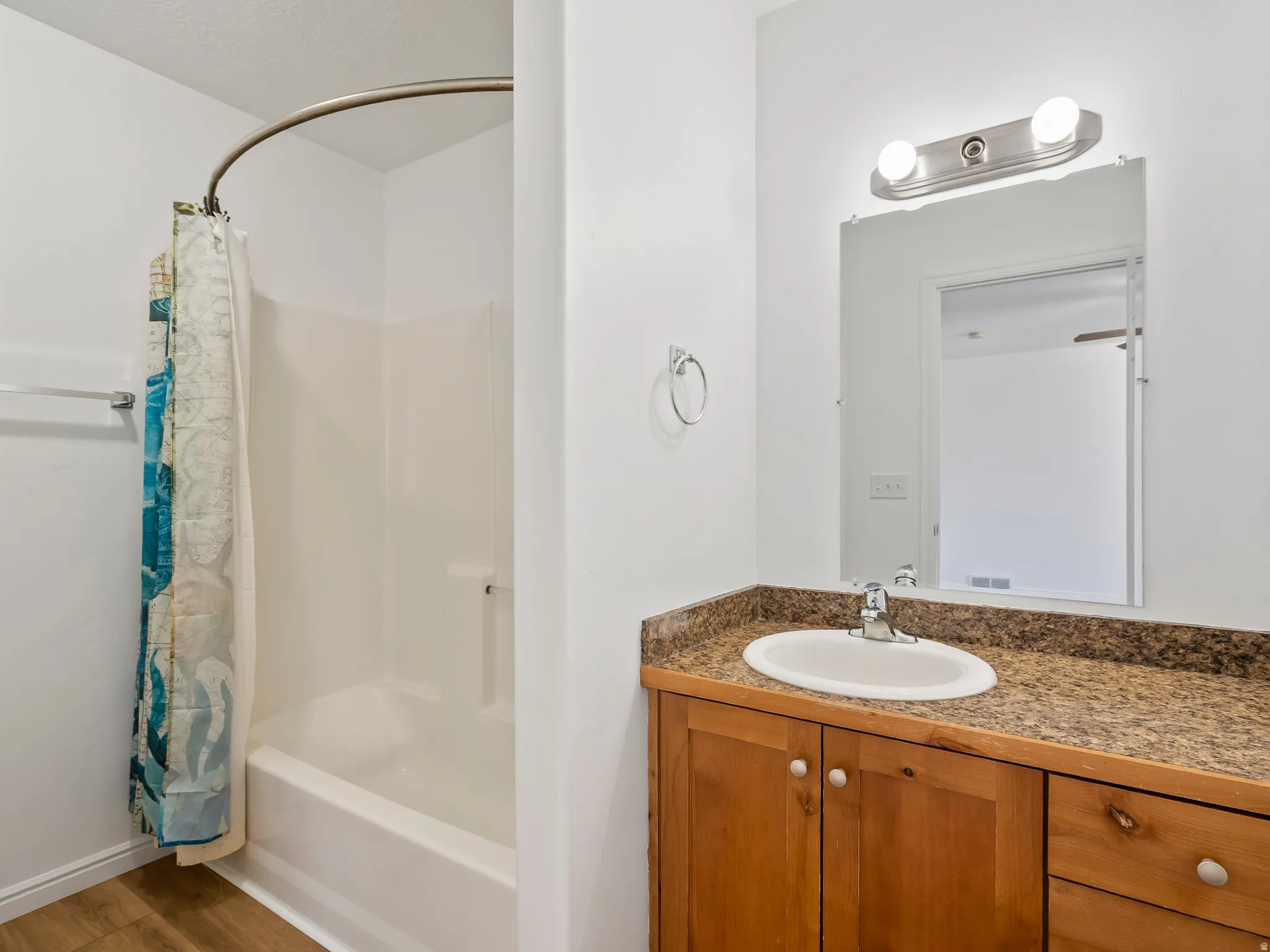 White tub and shower combination with a curved shower rod
