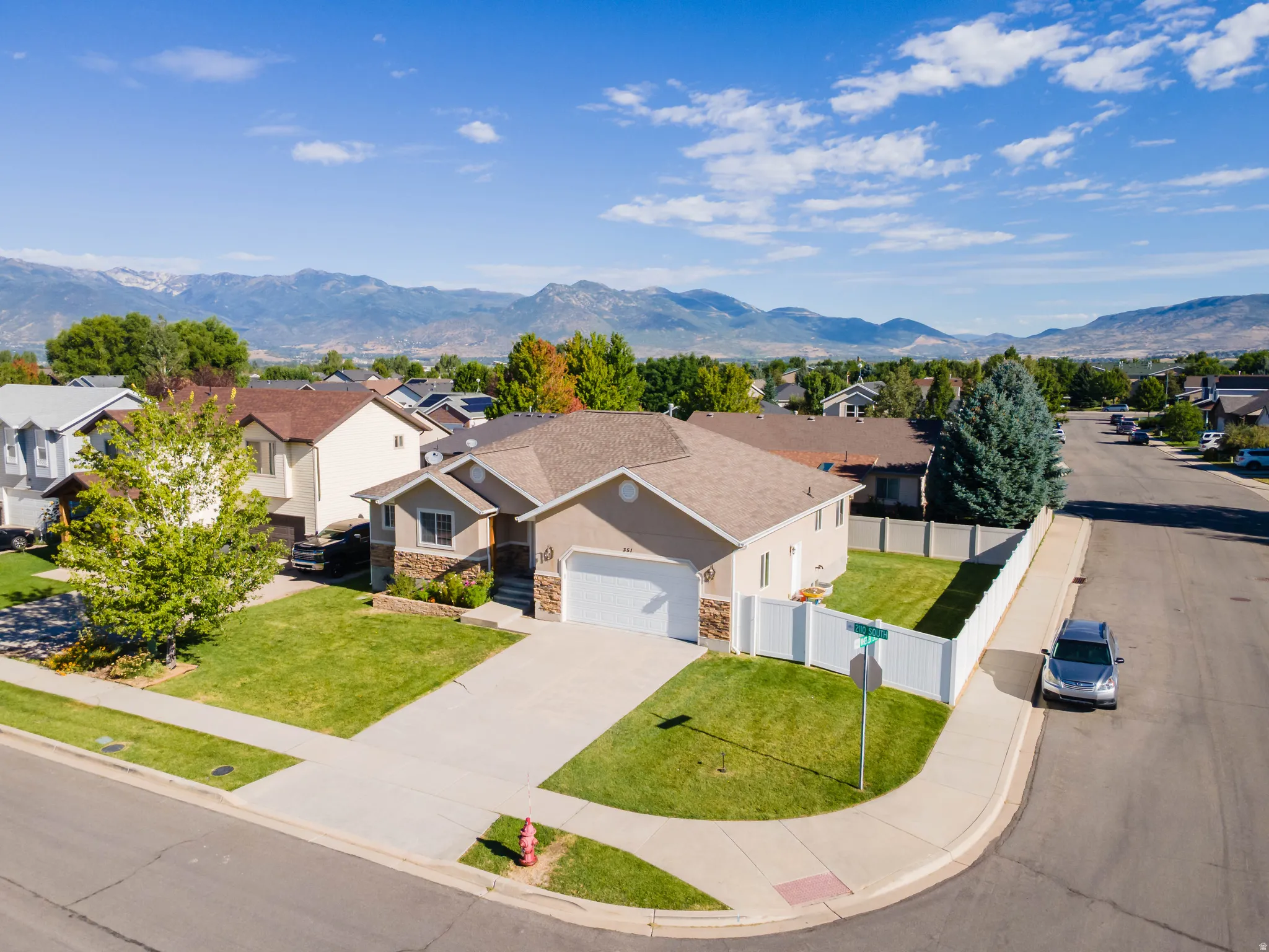 Single-story residence with a two-car garage, stone accents, and a fenced backyard