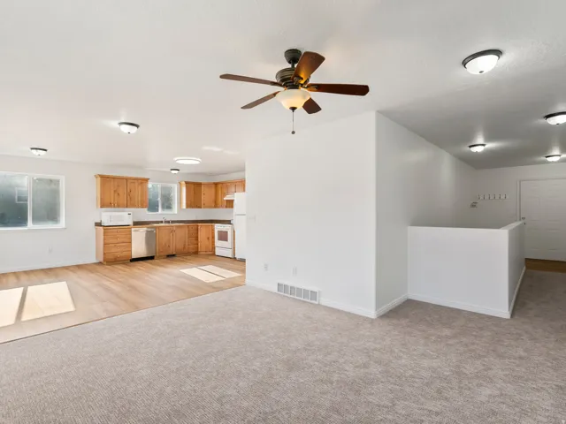 Open-concept living area with wood-finish flooring and carpet