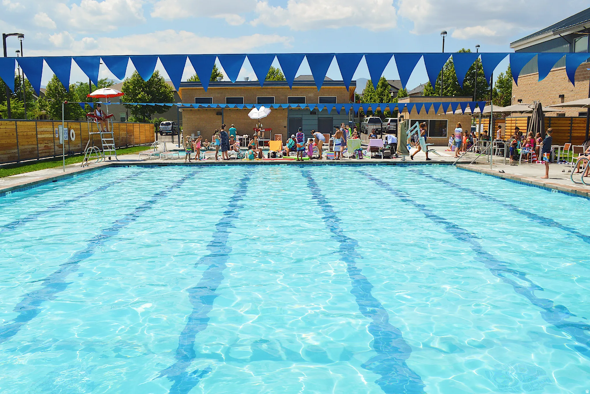 Community swimming pool with lap lanes, adjacent pool deck, and perimeter fencing