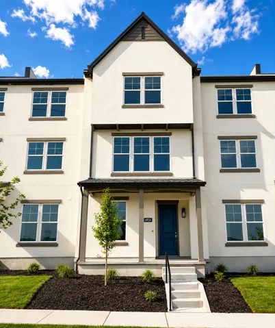 Multi-story residence featuring a prominent gabled roofline, white stucco exterior, and a dark blue entry door