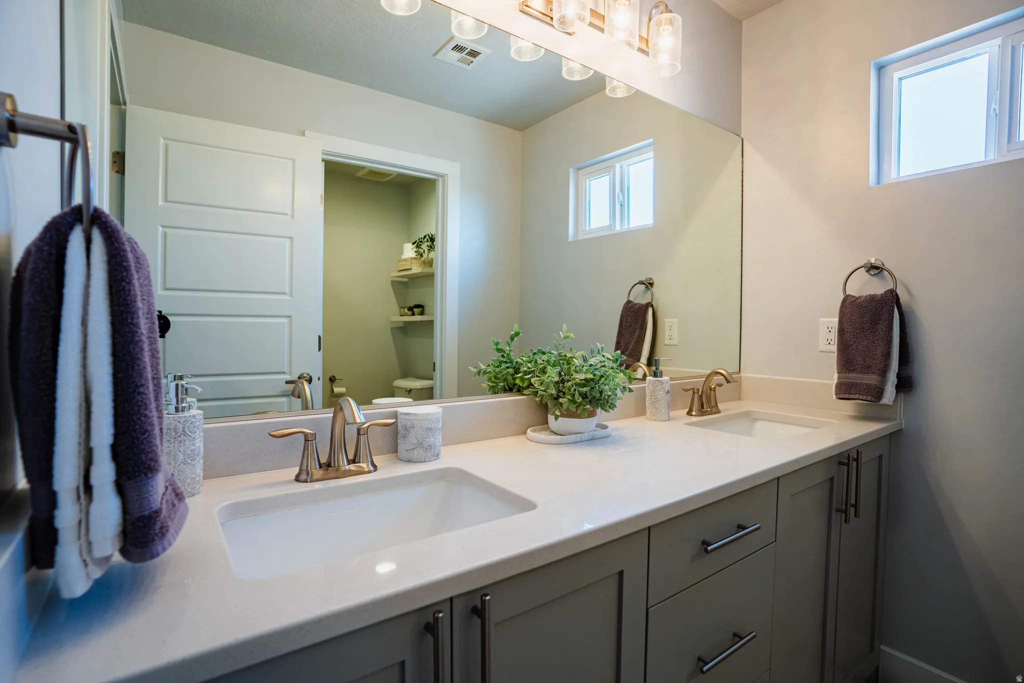 Dual vanity with integrated sinks, light-toned countertop, and undermount cabinetry