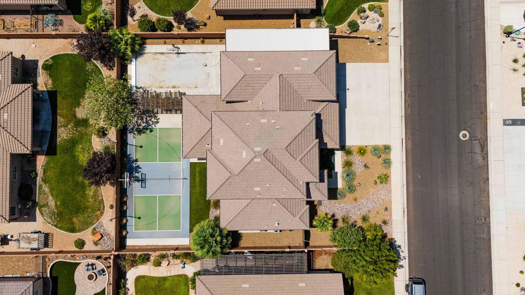 Expansive property featuring a multi-sport court, mature landscaping, and an attached covered structure