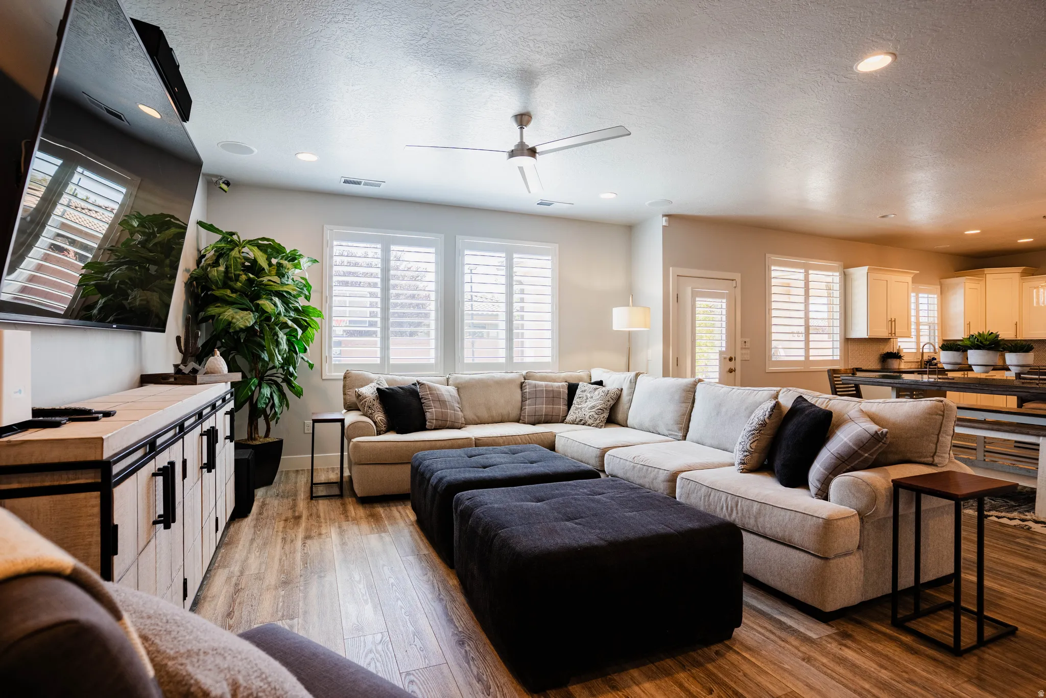 Open-concept living area featuring wood-finish flooring, recessed lighting, and a ceiling fan