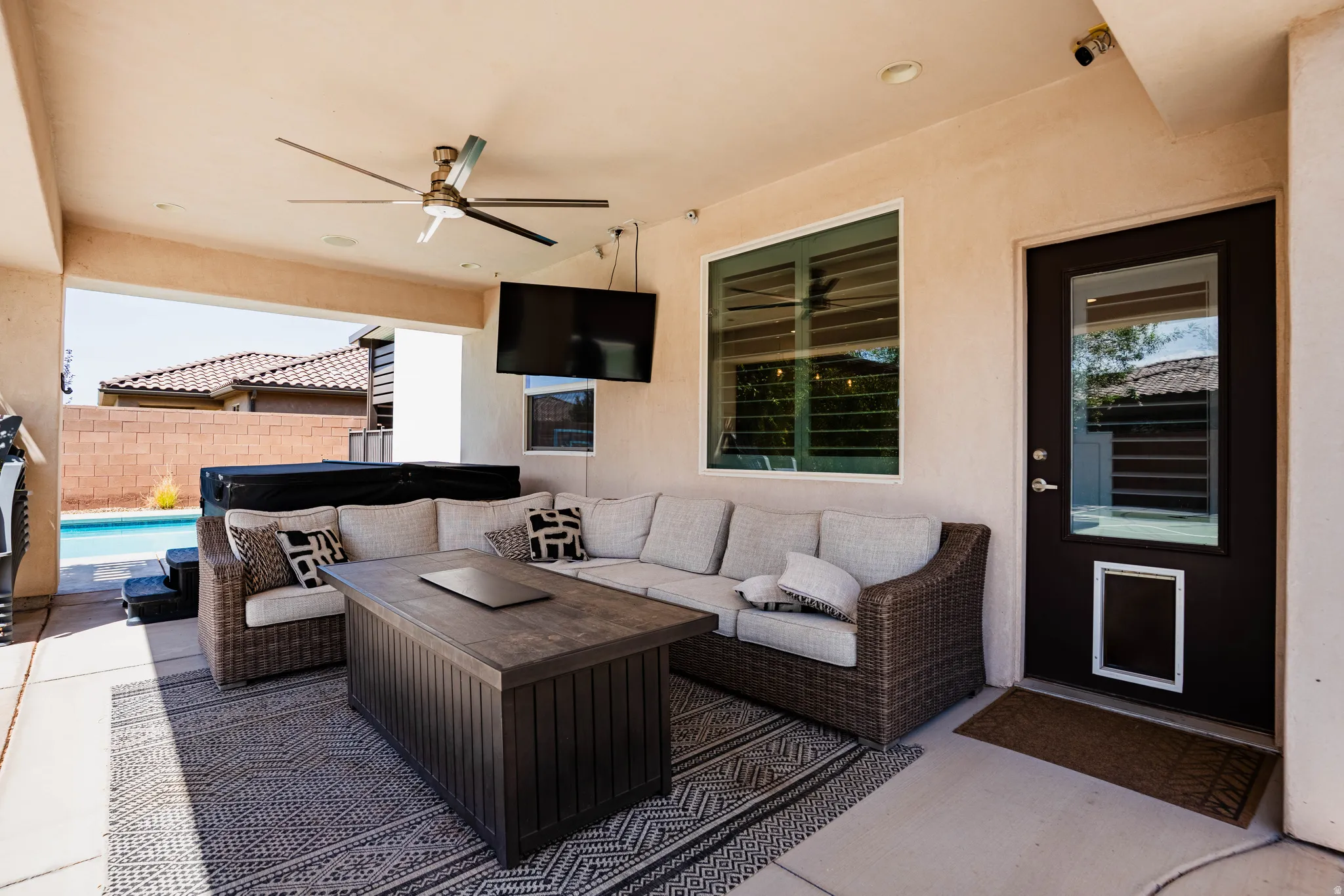 Covered patio with a ceiling fan, recessed lighting, and a dark-framed glass-paneled door