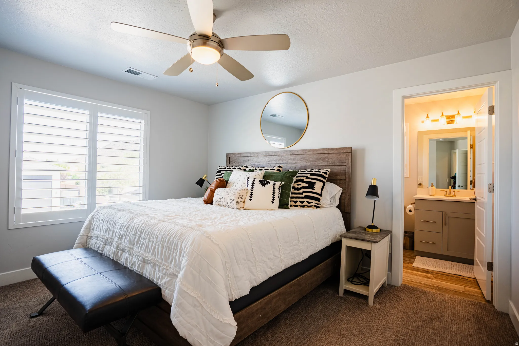 Room featuring a ceiling fan, window with white plantation shutters, and carpet flooring