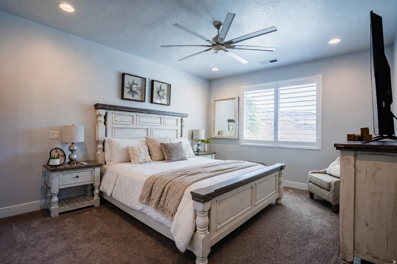 Recessed ceiling lighting, ceiling fan, white window shutters, and carpet flooring