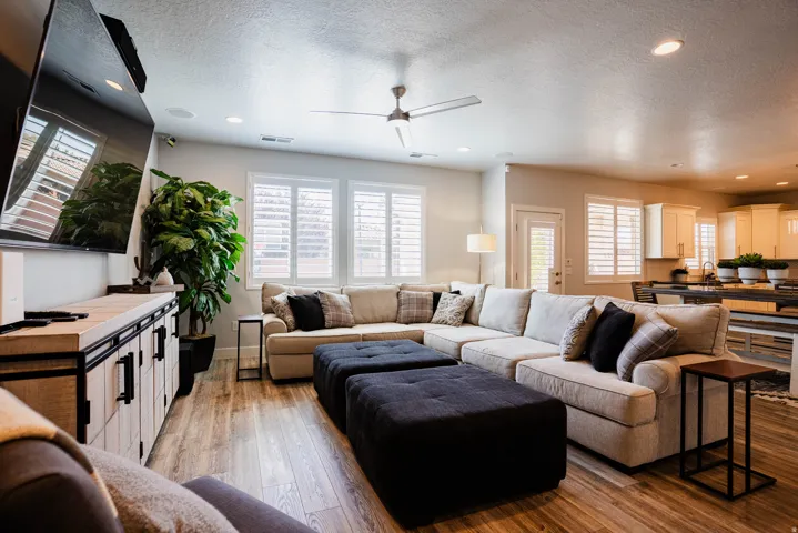 Open-concept living area featuring wood-finish flooring, recessed lighting, and a ceiling fan