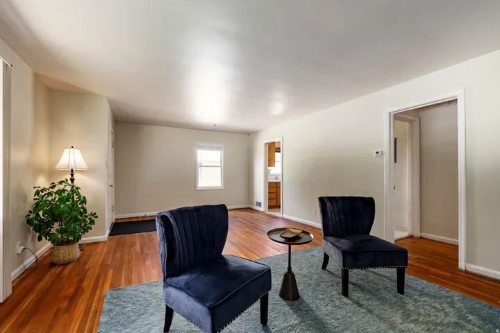 Hardwood flooring, neutral wall tones, white trim, and a window with blinds