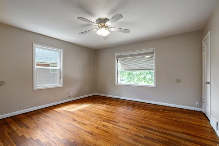 Hardwood flooring, painted walls, ceiling fan, and white trim