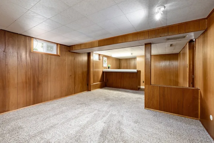 Wood-paneled walls and a built-in bar area create a distinct atmosphere