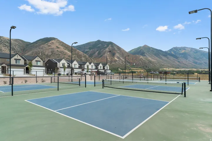 Multiple pickleball courts with perimeter fencing and integrated lighting