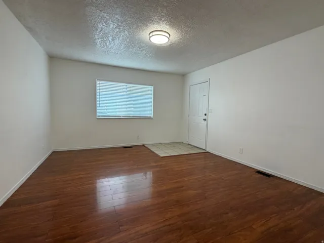 Wood-finish flooring, white walls, and a ceiling-mounted light fixture