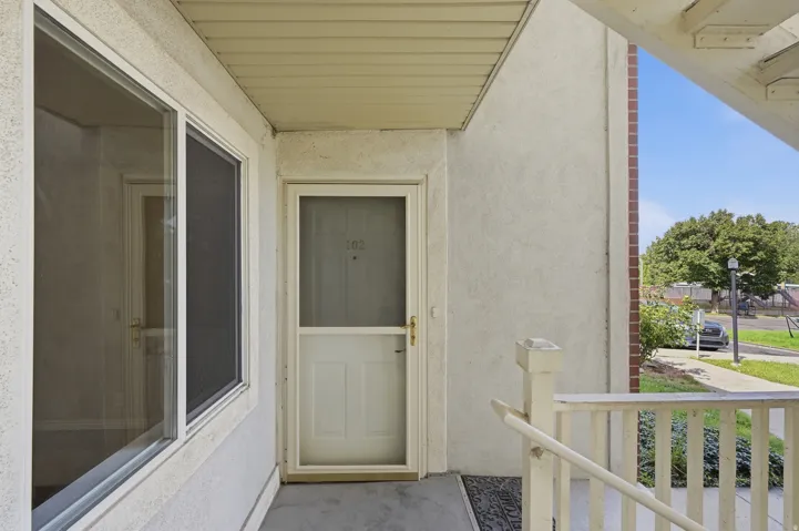 Exterior entrance featuring stucco siding and a white storm door