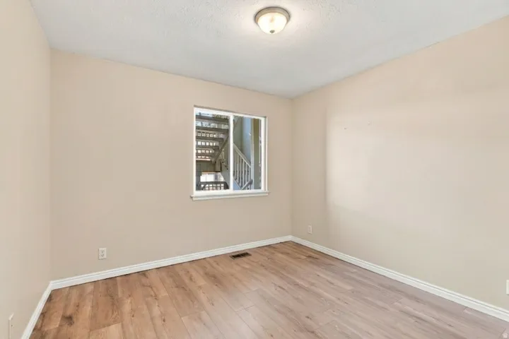 Wood-finish flooring, neutral wall tones, white trim, and a semi-flush mount ceiling light