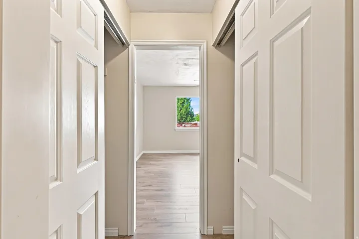 Sliding panel doors, wood-finish flooring, and a window with natural light