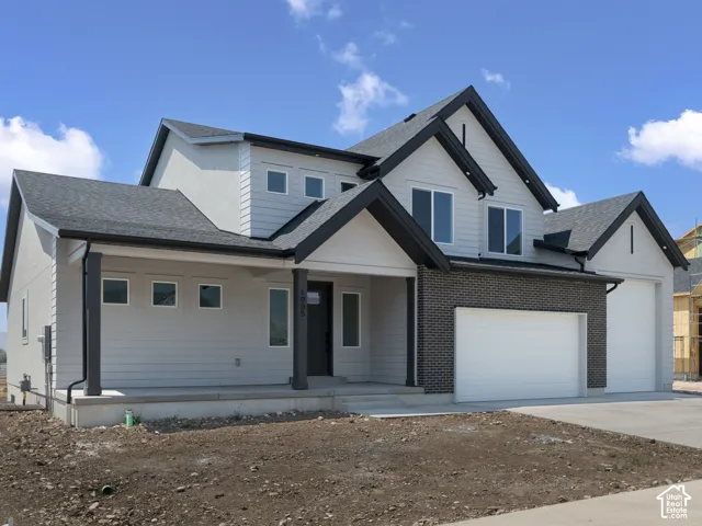 Contemporary exterior design with multi-level rooflines, light gray siding, and dark gray brick accents