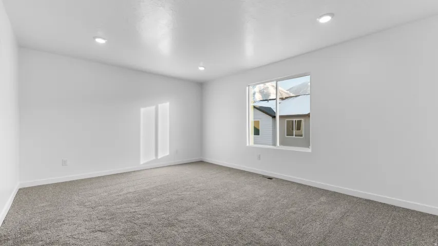 White walls with recessed lighting and a window