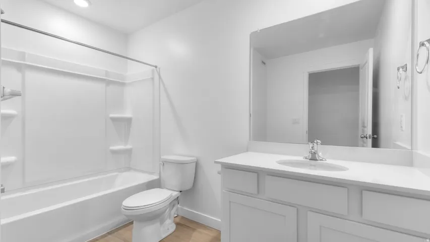 White vanity with a solid surface countertop, undermount sink, and chrome faucet