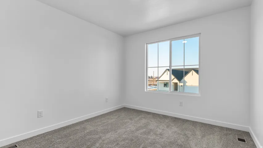 Neutral wall color, carpet flooring, and a multi-pane window