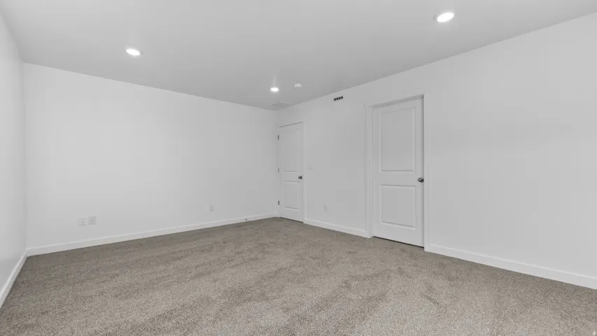 Recessed lighting, light gray carpet, and two paneled interior doors with round hardware