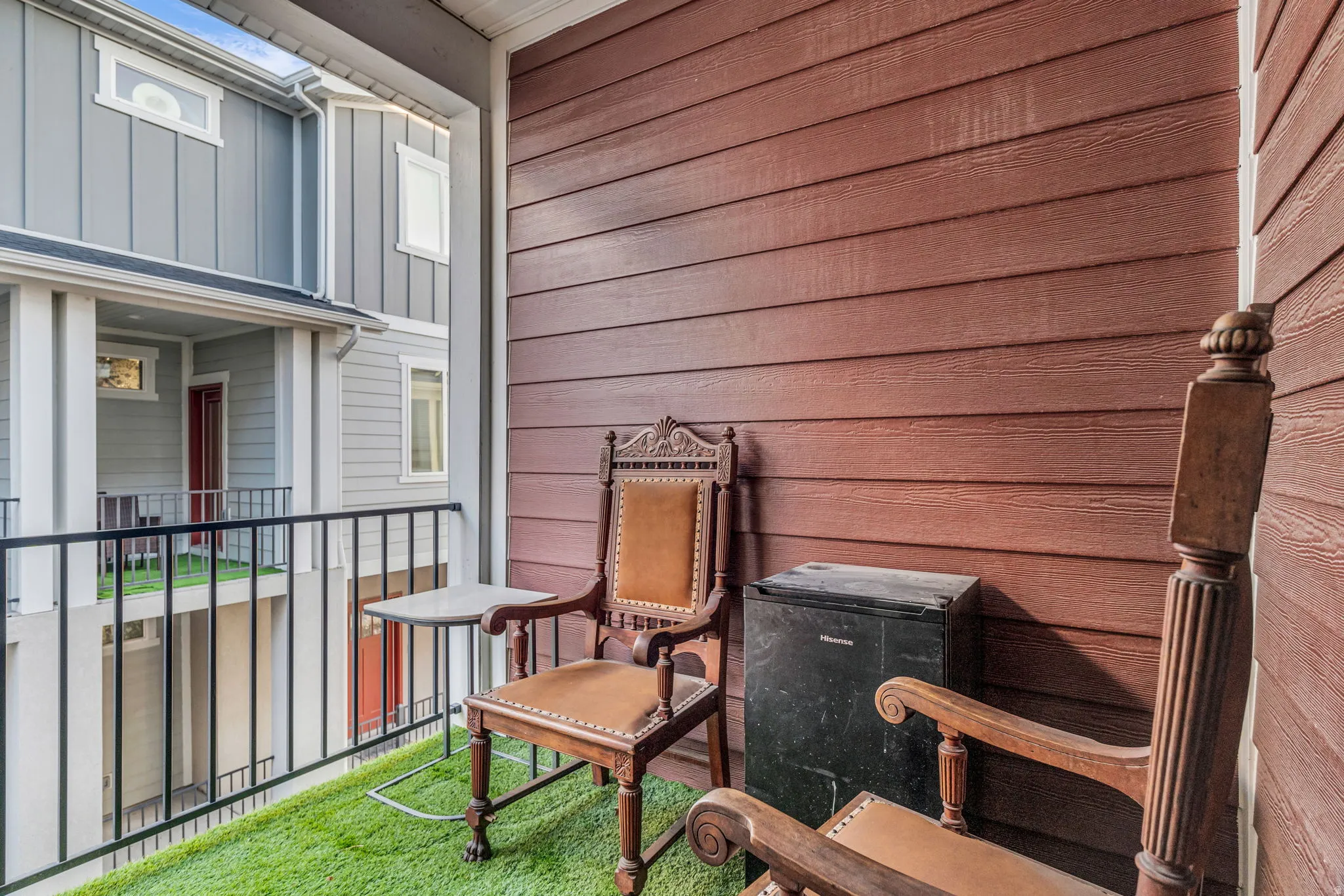 Balcony with artificial turf flooring and black metal railing