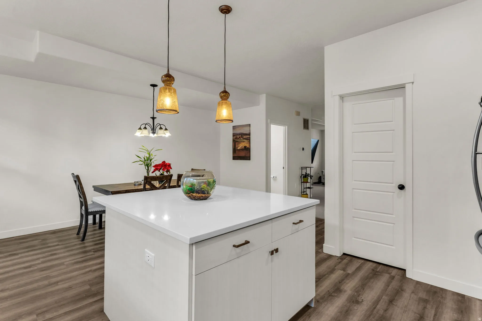 Kitchen island featuring a white countertop and base cabinetry with bronze hardware