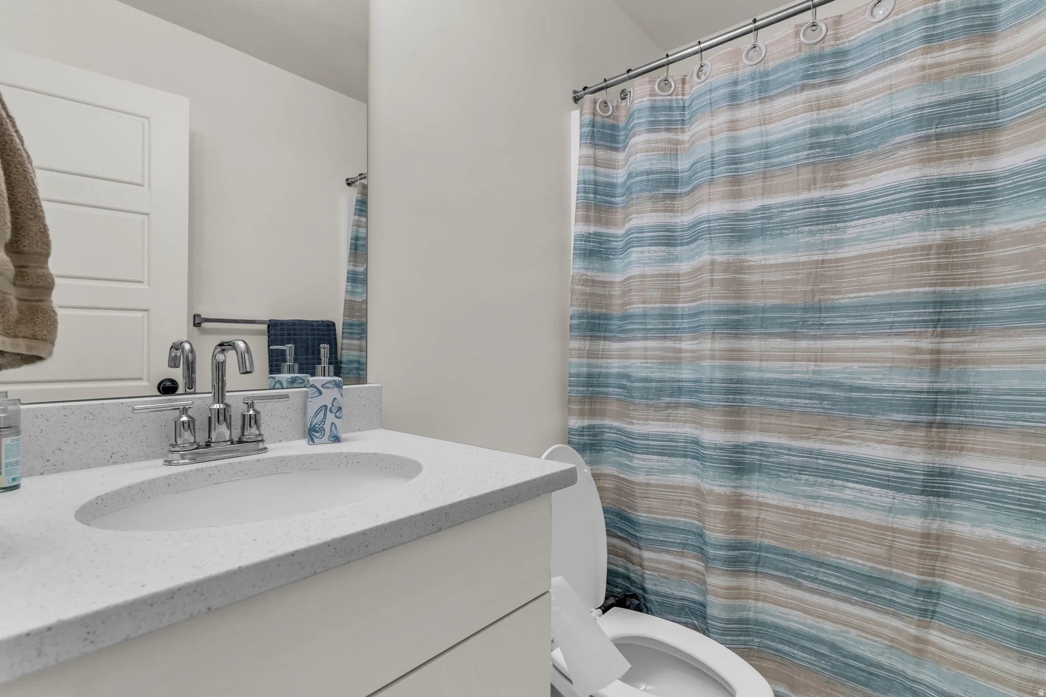 Vanity with an integrated sink, polished chrome faucet, and white countertop