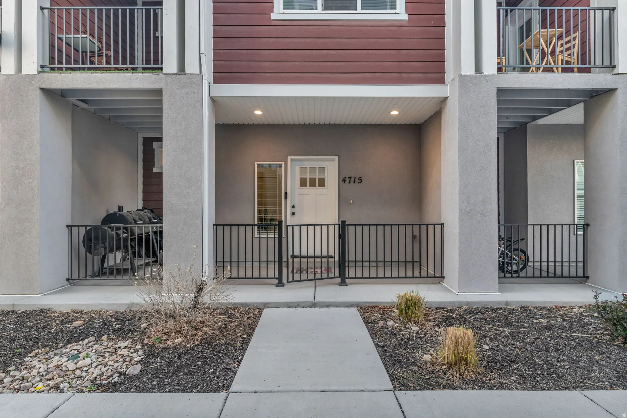 Front entry with a white door, overhead lighting, and an address number