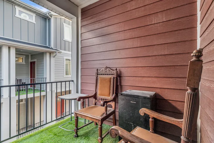 Balcony with artificial turf flooring and black metal railing