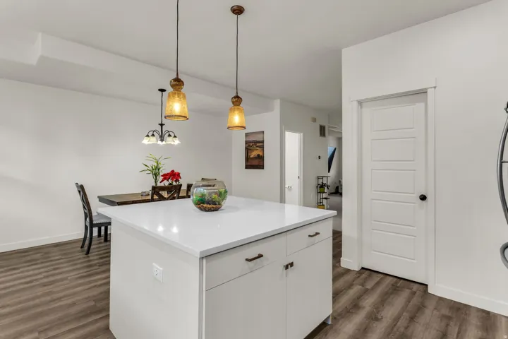 Kitchen island featuring a white countertop and base cabinetry with bronze hardware