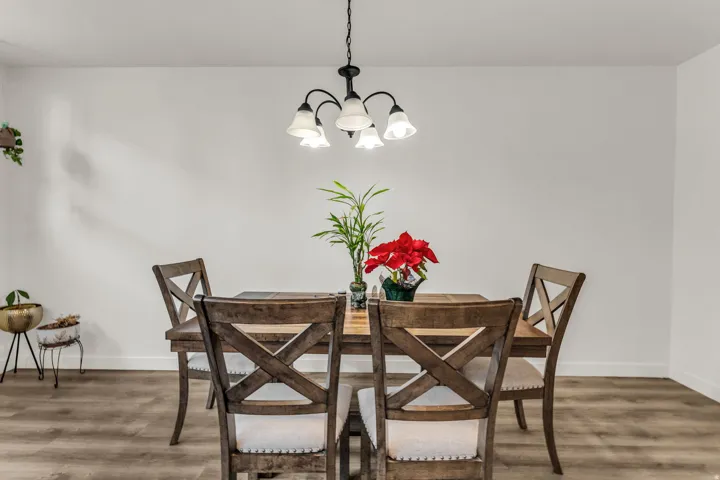 Wood-finish flooring with white walls and a multi-arm chandelier