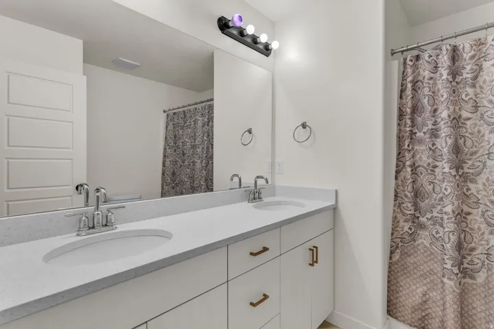 Double vanity with integrated sinks, light-toned countertops, and brushed nickel faucets