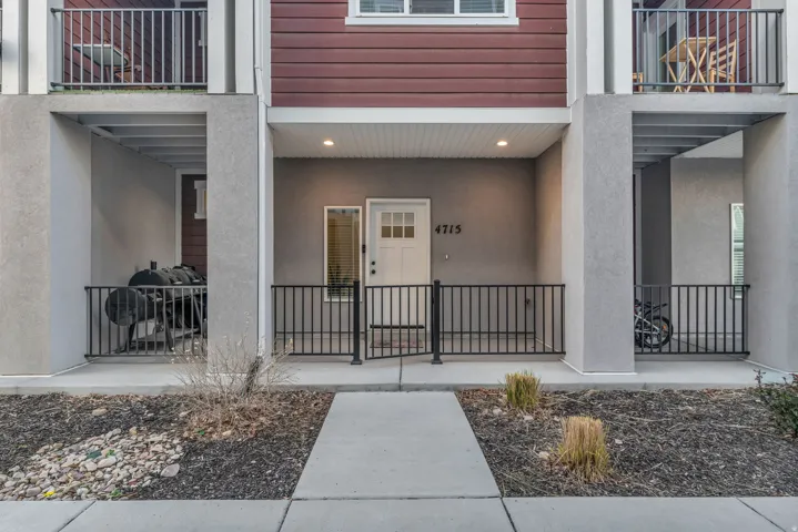 Front entry with a white door, overhead lighting, and an address number