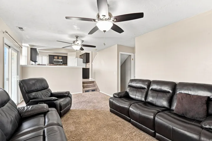 Recessed lighting, ceiling fans, sliding glass door, and carpet flooring