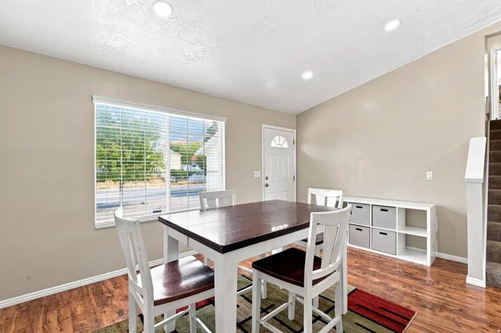 Recessed ceiling lighting, wood-finish flooring, half-lite entry door, built-in open shelving, and a large window