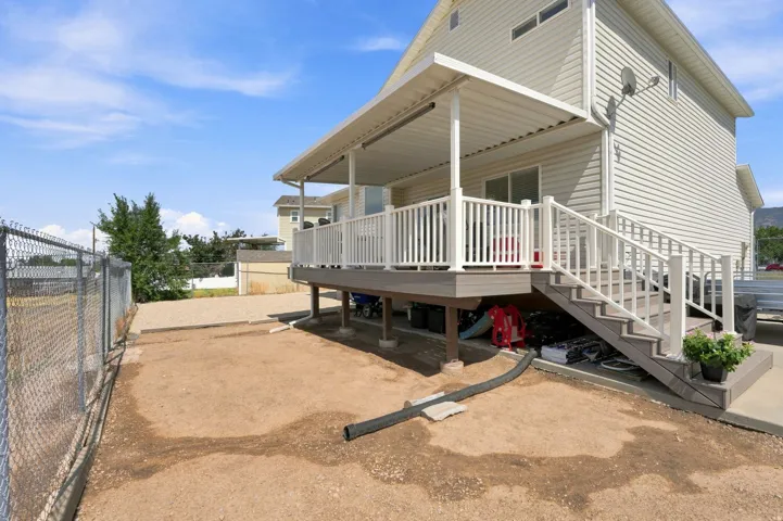 Exterior deck with white railing, covered patio space, and composite steps
