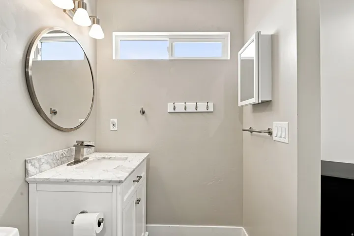 Vanity with a stone finish countertop, integrated sink, and brushed nickel single-handle faucet