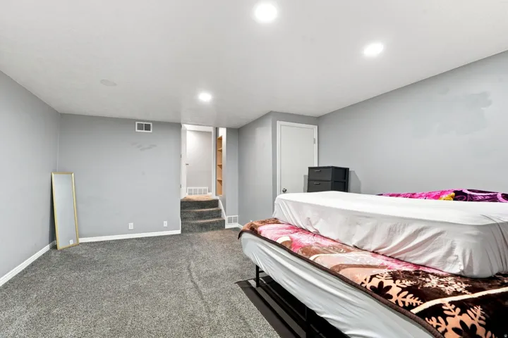Gray carpeting, recessed ceiling lighting, gray painted walls, and white trim