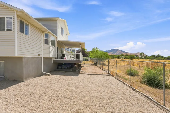 Exterior with light-colored siding and a covered deck featuring white railings