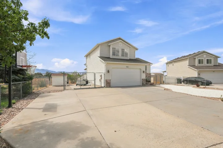 Two-story residence with a two-car garage, stone accents on the facade, and a paved driveway