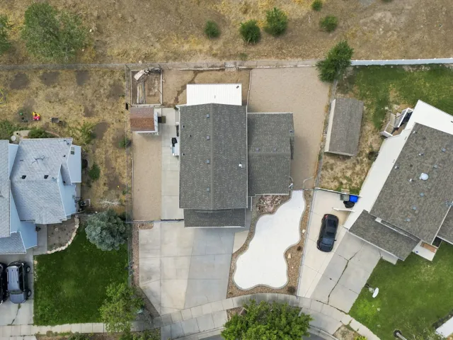 Two-story residence with a shingled roof, accompanied by an attached garage and a detached shed