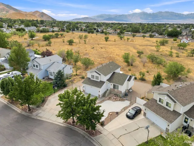 Two-story residence featuring a two-car garage, partial stone facade, and a paved driveway