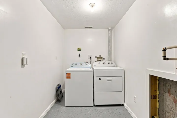Dedicated utility space with durable flooring and overhead lighting