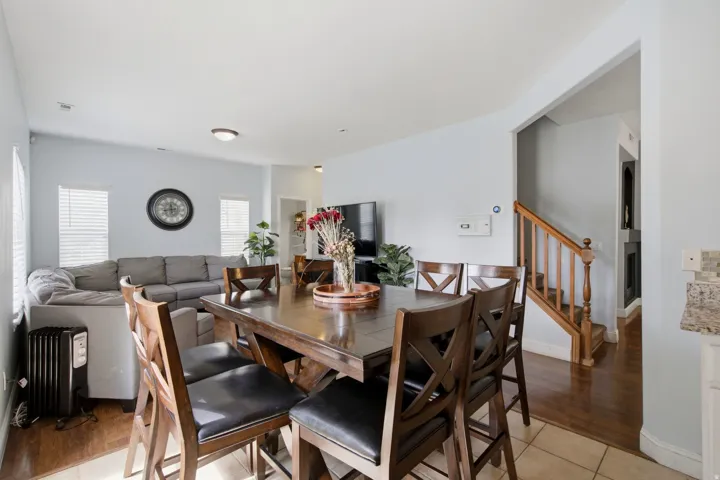 Open-concept living space with light-toned walls, recessed lighting, and wood-finish flooring